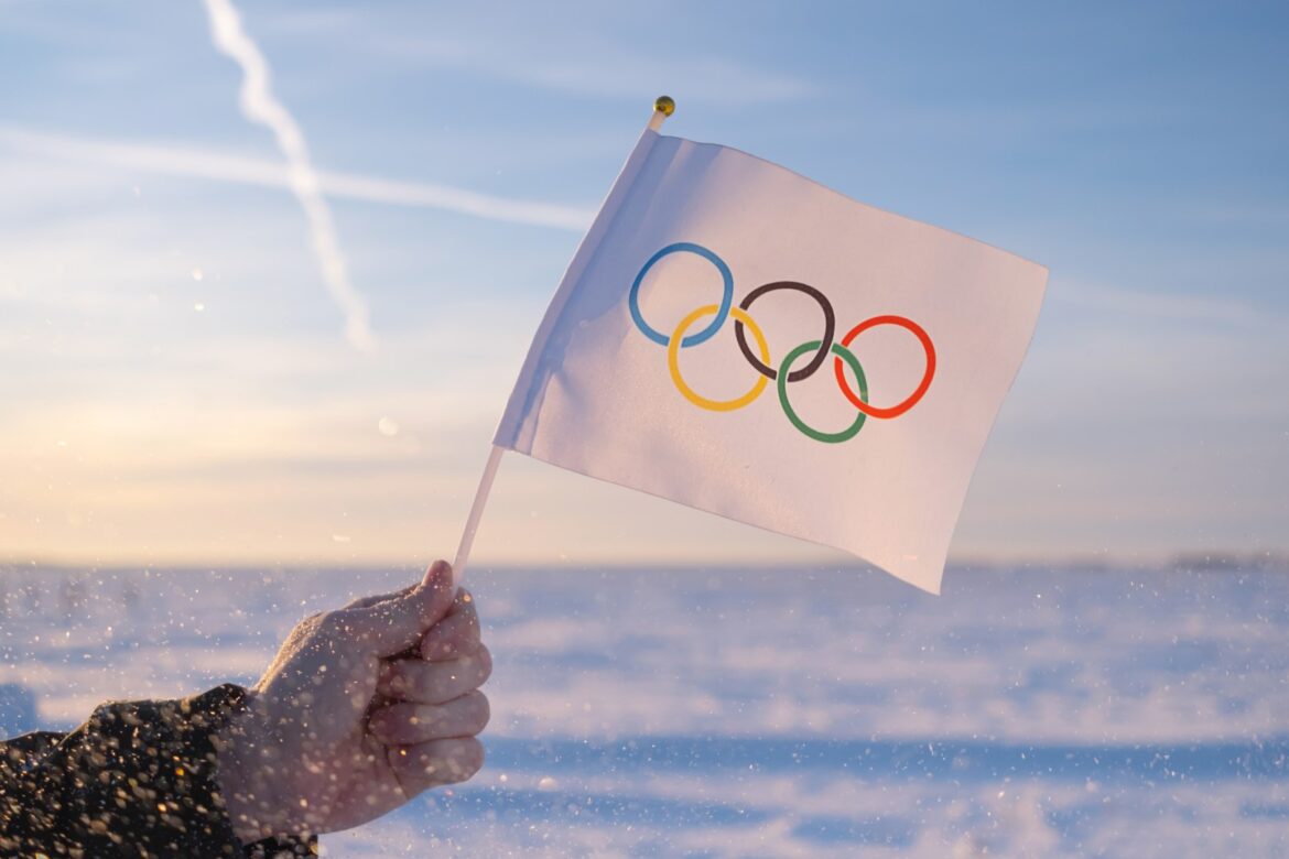 Biggest upsets in the history of Olympics, Olympics logo on a white flag in person's hand in front of sea
