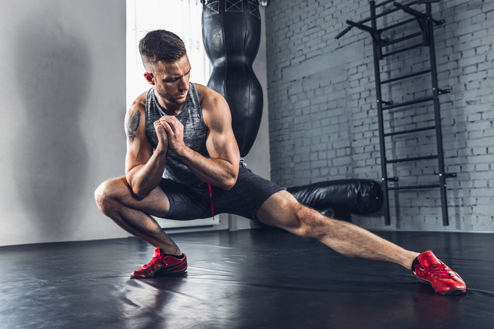 young fit athlete exercising stretching for optimum performance