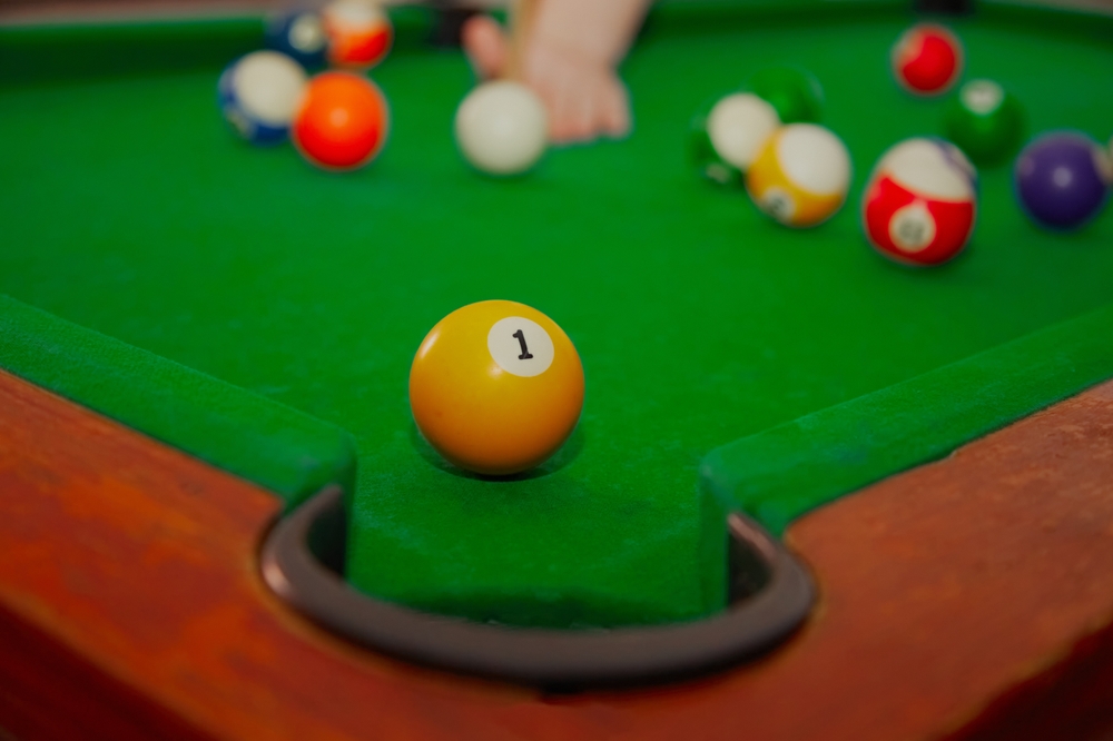 Playing billiards, ball in front of the pocket, accurate hit in billiards, ball number 1 in front of the pocket, billiards game