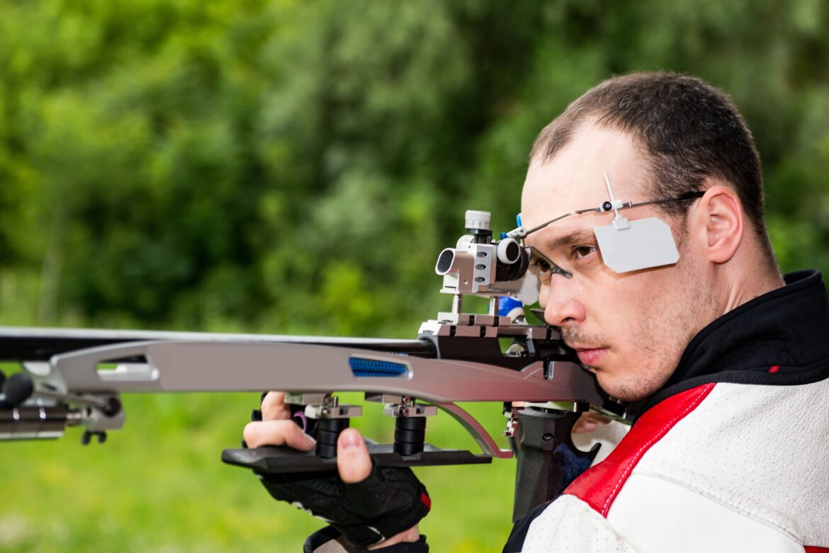 Calm man practicing shooting. Man on free rifle triaing outdoors