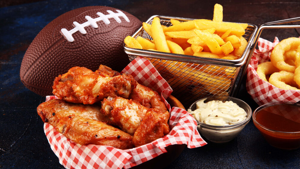 chicken wings, fries and onion rings for football on a table. Great for Bowl football Game