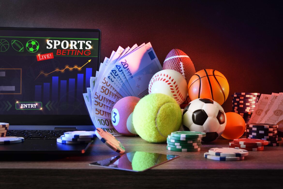 Conceptual background of online sports betting with laptop with application on desk with objects representing online sports batting